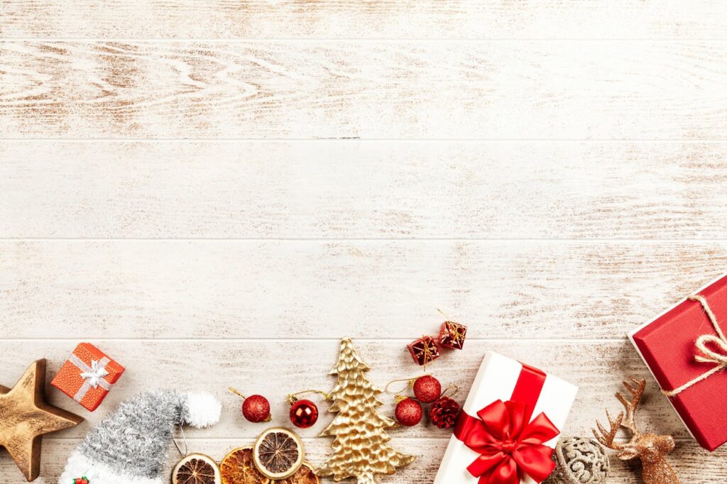 A flatlay of Christmas gifts and ornaments on a rustic wooden background, perfect for holiday themes.